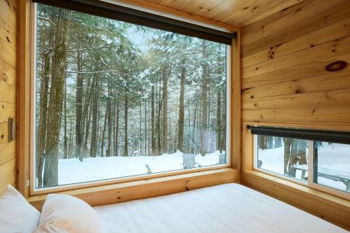 a bedroom with a large window in a forest at Postcard Cabins Chattahoochee, Outdoor Collection by Marriott Bonvoy in Suches