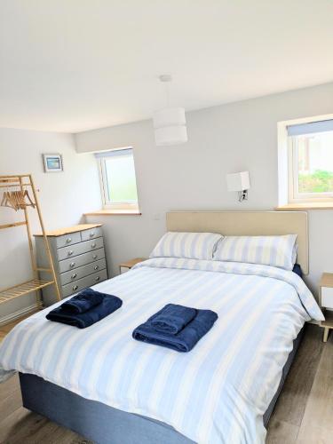 a bedroom with a bed with blue towels on it at Sterennyk in Helston