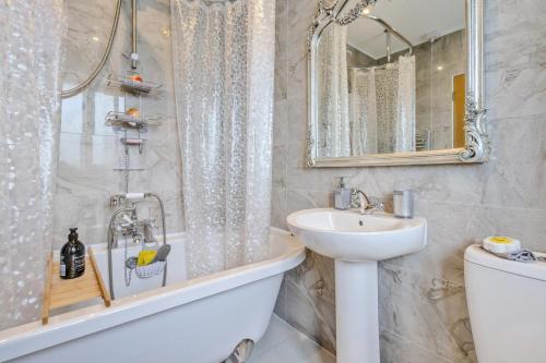 a bathroom with a sink and a tub and a toilet at 3 Bed in Forden oc-c30173 in Forden