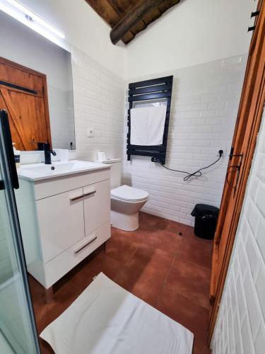 a white bathroom with a toilet and a sink at Refúgio de Monsaraz in Monsaraz
