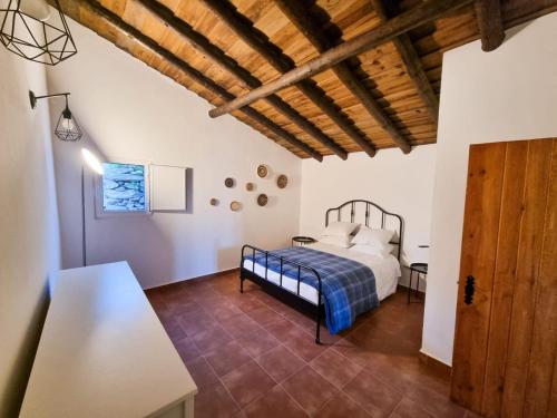 a bedroom with a bed and a wooden ceiling at Refúgio de Monsaraz in Monsaraz