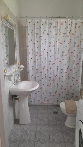 a bathroom with a sink and a shower curtain at Georgia's Summer House in Karianí