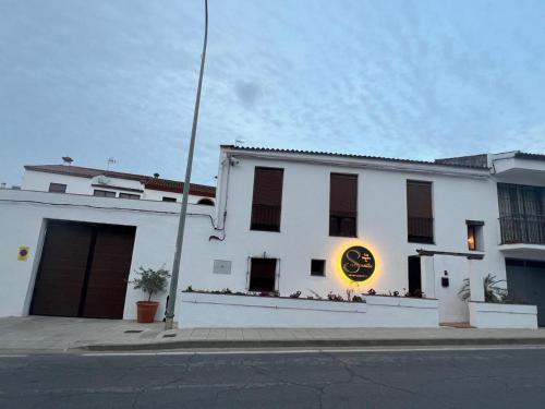 a white building with a clock on the side of it at Los Ángeles de Sanmartín in Jimena de la Frontera