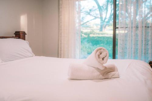 a white towel sitting on a bed with a window at Vineyard Retreat in the Heart of McLaren Vale in McLaren Vale