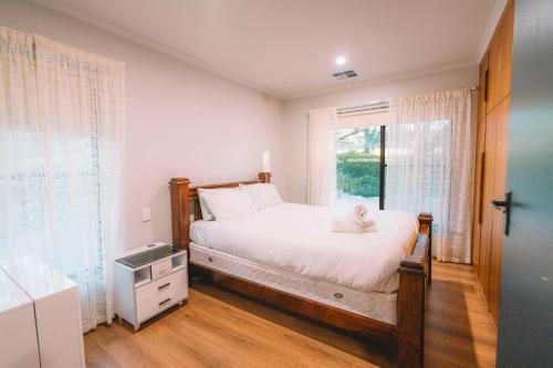 a bedroom with a bed and a window at Vineyard Retreat in the Heart of McLaren Vale in McLaren Vale