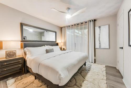a bedroom with a large bed and a mirror at Stylish Dallas Condo Resort-Style Pool in Dallas