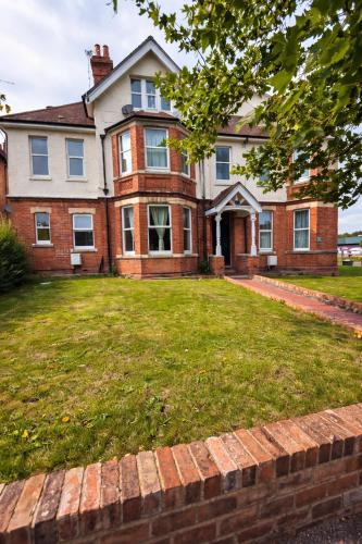 an old brick house with a lawn in front of it at Spacious - Free Parking - Sleeps 6 - M20-FolkestoneCentralStation in Folkestone