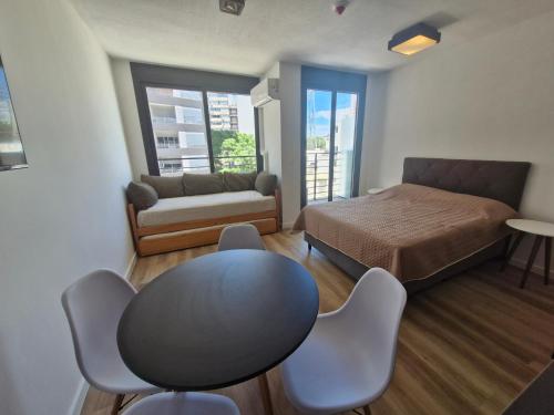 a room with a bed and a table and chairs at Cerca de todo, monoambiente con parking in Montevideo