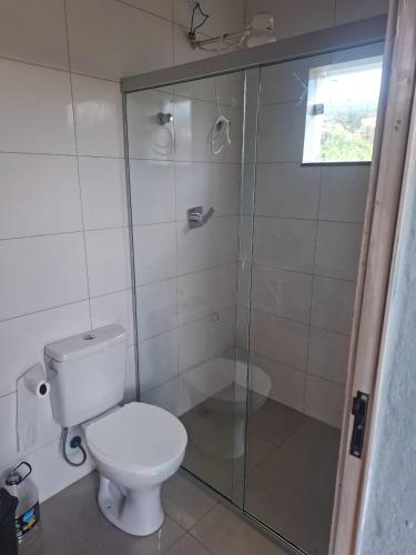 a bathroom with a toilet and a glass shower at Cantinho da Meirinha in Santana do Riacho