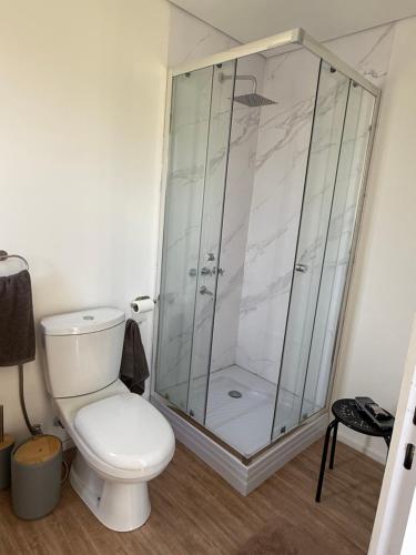 a bathroom with a toilet and a glass shower at Complejo Nomade Home in Marcos Juárez