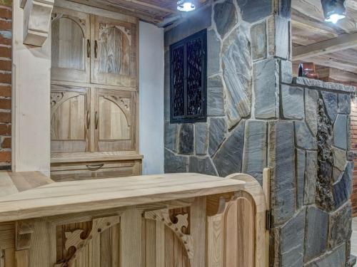 a kitchen with wooden cabinets and a stone wall at Pokoje Gościnne Światłomir in Zakopane