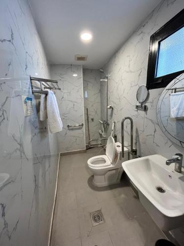 a bathroom with a white toilet and a sink at فندق الدوبلي أجياد in Quai
