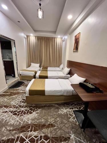 a hotel room with two beds and a desk at فندق الدوبلي أجياد in Quai