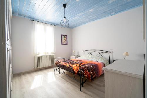 a bedroom with a bed and a blue ceiling at Casa Vacanze Leandra in San Costanzo
