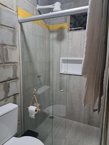 ein Badezimmer mit Glasdusche und WC in der Unterkunft Rustica e Charmosa in Santa Cruz Cabrália