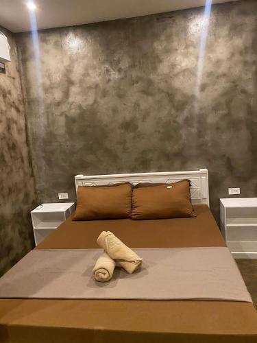 a bedroom with a bed with a towel on it at Journeyy INN in General Luna