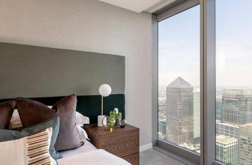 a bedroom with a bed and a large window at 3 Bedrm Luxury Serviced Apartment in Canary Wharf in London