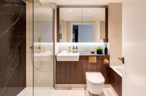 a bathroom with a toilet and a sink and a shower at 3 Bedrm Luxury Serviced Apartment in Canary Wharf in London