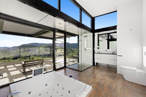 a bathroom with a tub and a view of the mountains at Riverdance At Conondale in Conondale