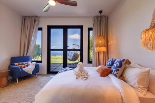 a bedroom with a large bed and a blue chair at Villa Odyssea BVI in Tortola Island