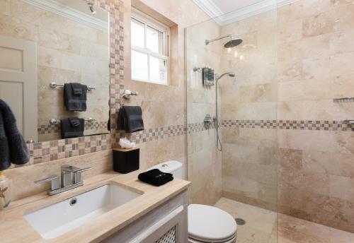 a bathroom with a shower and a toilet and a sink at Bianca Bay 3 Bedroom West Coast Beach Front Villa in Saint James