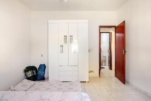 a bedroom with a bed and a white cabinet at Descanso Perfeito Na Região Dos Lagos in São Pedro da Aldeia