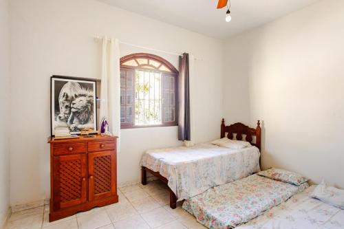 a bedroom with two beds and a dresser and a window at Descanso Perfeito Na Região Dos Lagos in São Pedro da Aldeia