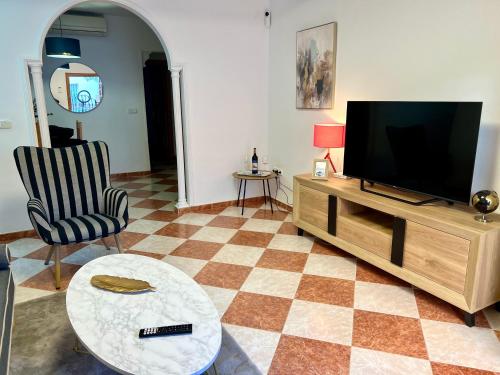 a living room with a flat screen tv and a table at Casa Centro Fuengirola Gran Patio in Fuengirola