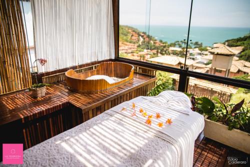 a bedroom with a tub and a bed in a room at La Pedrera Small Hotel & Spa in Búzios