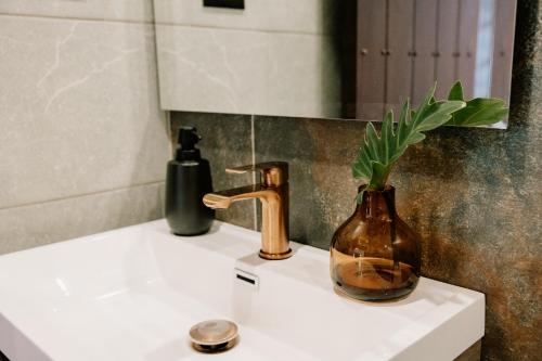 a vase sitting on a sink in a bathroom at Hotel Catleya Royal Club in Pereira