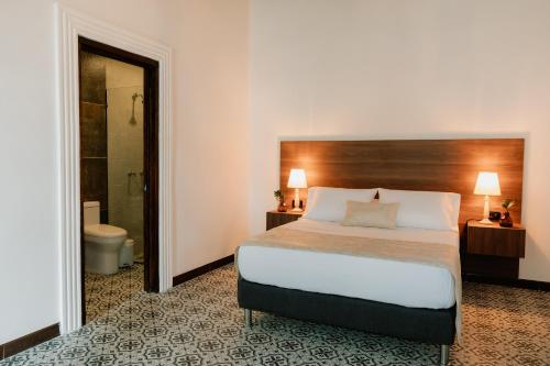 a hotel room with a bed and a bathroom at Hotel Catleya Royal Club in Pereira