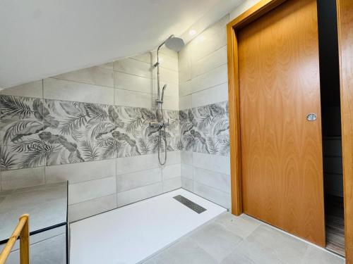 a bathroom with a shower stall and a door at Casa Alma Serena in Batalha
