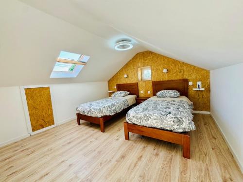 a bedroom with two beds and a skylight at Casa Alma Serena in Batalha