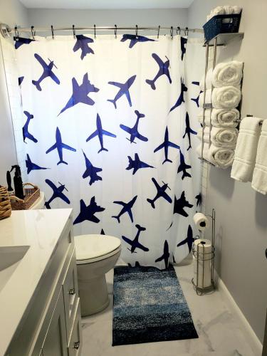 a bathroom with a shower curtain with blue birds on it at The Sky Lounge-Brunswick in Brunswick