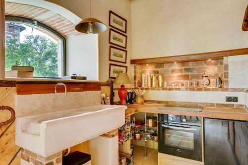 a large kitchen with a sink and a window at L'Ecurie Former stable with charm and light in Ingrandes
