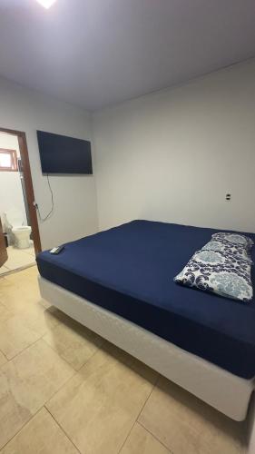 a bedroom with a bed with a blue bedspread at Apartamento 03 - Refúgio do Descanso in São Francisco do Sul