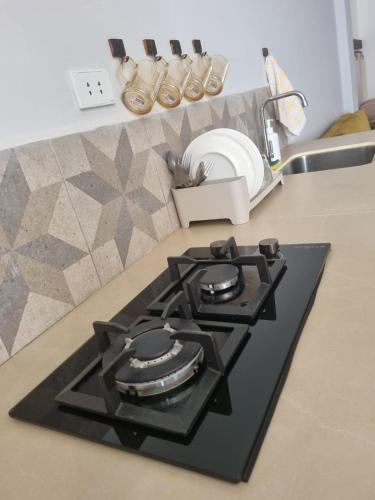 a kitchen counter with a stove and a sink at Mi casa en Sucre in Sucre