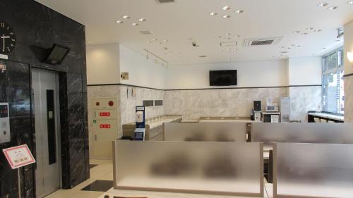 a waiting room with chairs and a clock on the wall at Toyoko Inn Kagoshima chuo eki Higashi guchi in Kagoshima