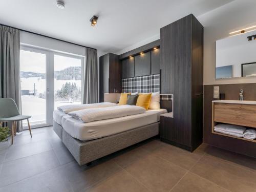 a bedroom with a large bed and a sink at Alpenchalet Lambert in Sankt Lambrecht