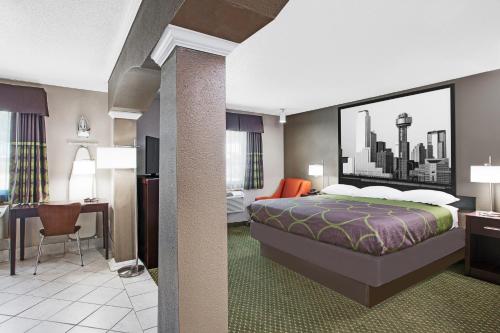 a hotel room with a bed and a desk at Super 8 by Wyndham Bedford DFW Airport West in Bedford