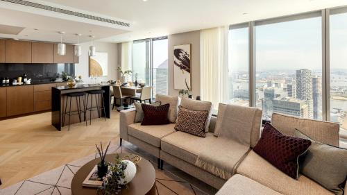 a living room with a couch and a kitchen at 3 Bedrm Luxury Serviced Apartment in Canary Wharf in London