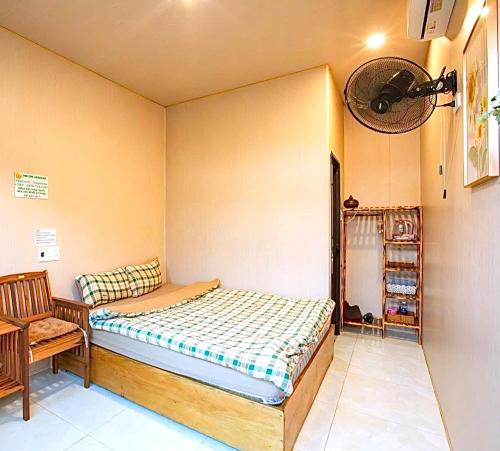 a small bedroom with a bed and a chair at Lamera Homestay & Coffee in Ben Tre