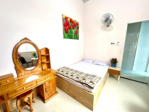 a bedroom with a mirror and a bed and a dresser at Lamera Homestay & Coffee in Ben Tre
