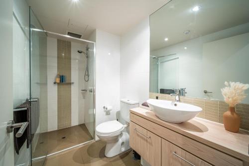 a bathroom with a sink and a toilet and a shower at Infinity on Morphett - Stay Central in the CBD in Adelaide