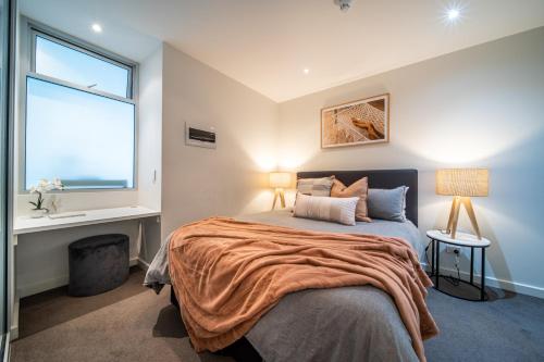 a bedroom with a large bed and a window at Infinity on Morphett - Stay Central in the CBD in Adelaide