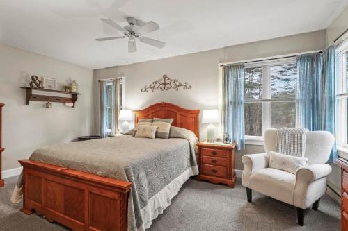 a bedroom with a bed and a chair and a fan at Paper Mill Pines Bed and Breakfast in Shickshinny