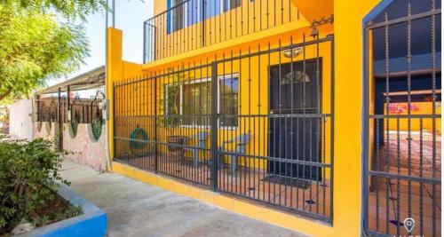 a yellow building with a gate in front of it at Great cozy place near Malecón in La Paz