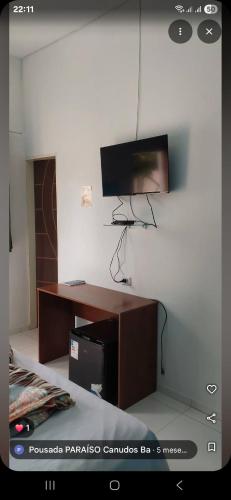 a living room with a tv on a wall at Pousada Paraiso in Canudos