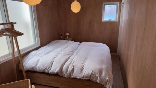 a white bed in a room with a window at Chayado 百八 善光寺門前 in Nagano