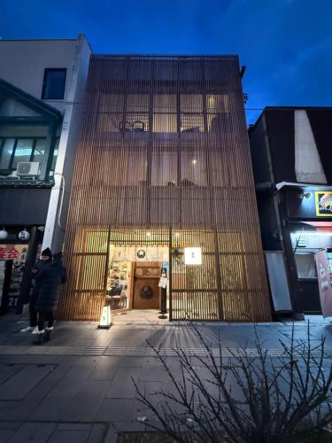 a person walking past a large building with a door at Chayado 百八 善光寺門前 in Nagano